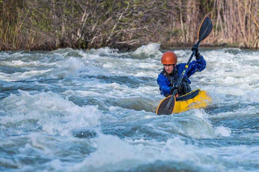 Uomo in kayak lungo un fiume