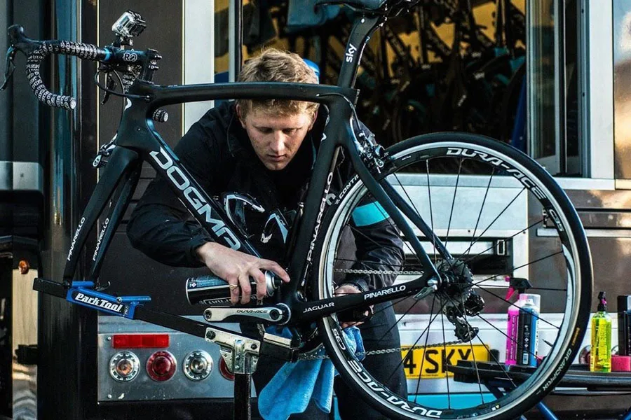 Man maintaining e-bike with various care products