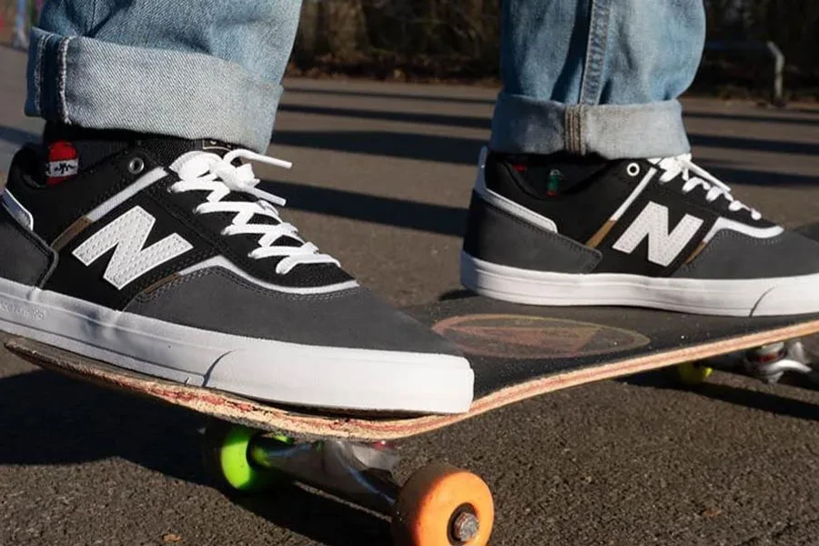 Mann auf einem Skateboard in grauen Skateschuhen