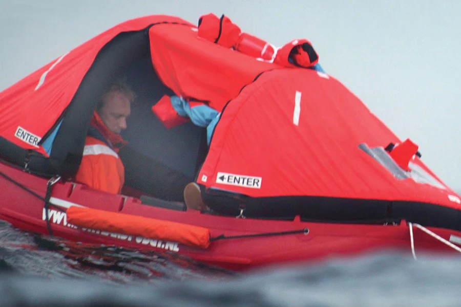 Hombre descansando dentro de una balsa salvavidas con dosel
