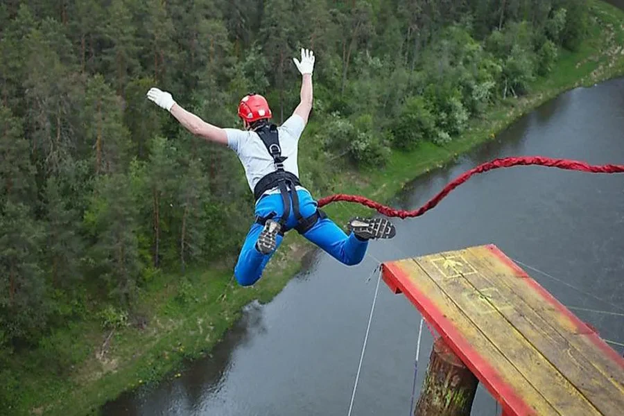 Mann wagt einen Sprung mit einem roten Bungee-Seil