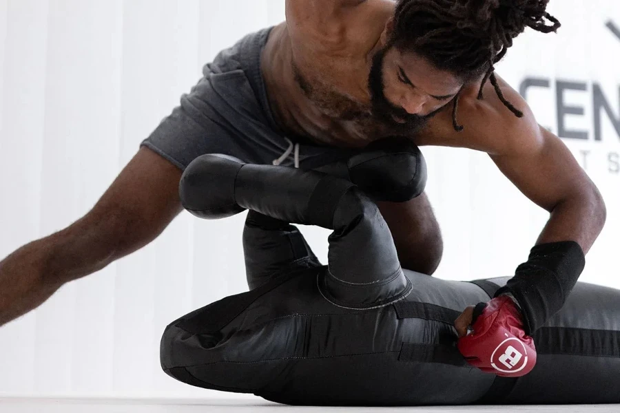 Homem lutando com um boneco de luta livre preto