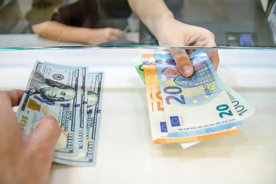Pessoas trocando dólares americanos por euros