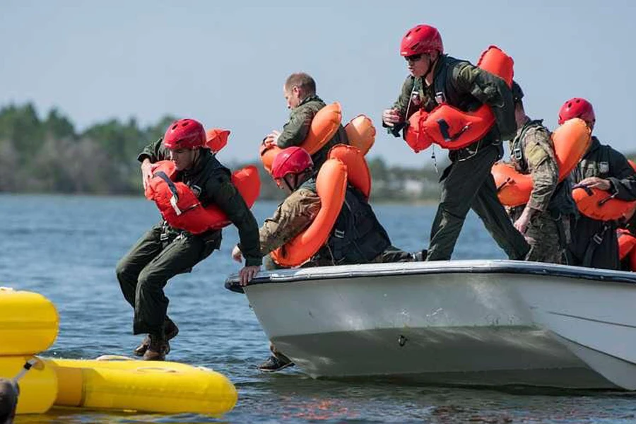 Gente saltando a una balsa salvavidas amarilla