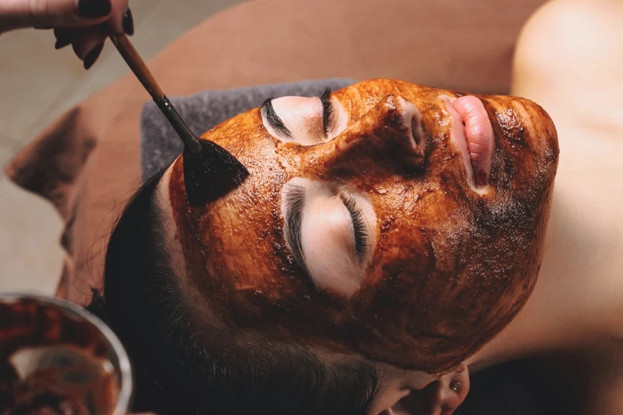 Persona recibiendo un tratamiento facial de cacao.