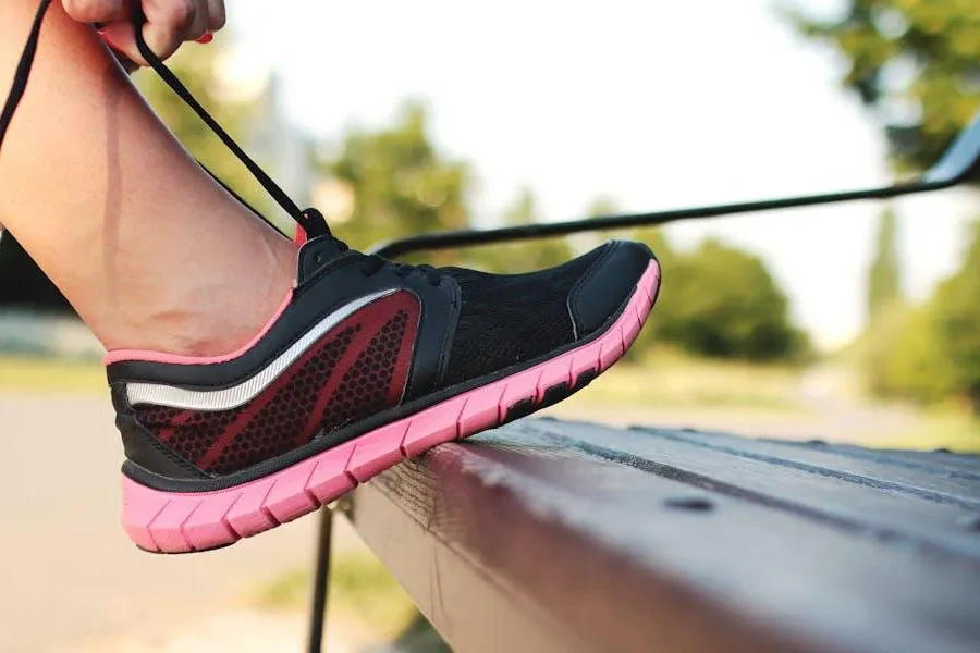 Person tying the laces of a black running shoe