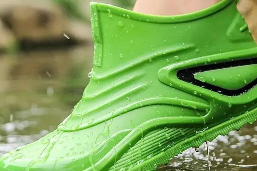 Persona que lleva una bota de agua verde resistente