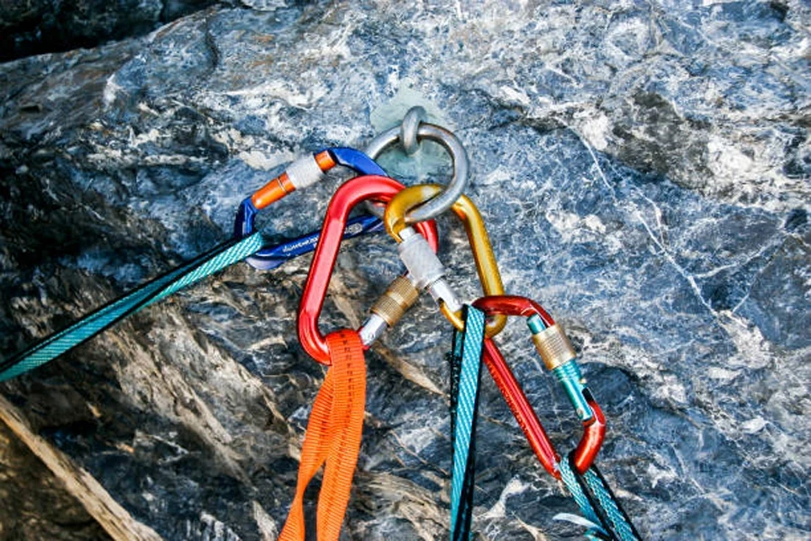 Satz Karabiner aus Seilen, die an einer Schlaufe am Felsen befestigt sind