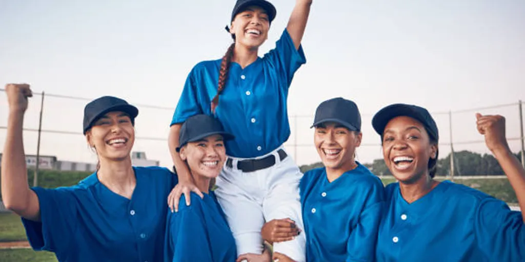 Squadra di softball che indossa abiti da softball blu e bianchi abbinati