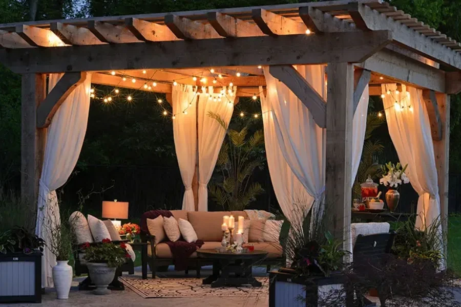 Impresionante sala de estar al aire libre con guirnaldas de luces y velas