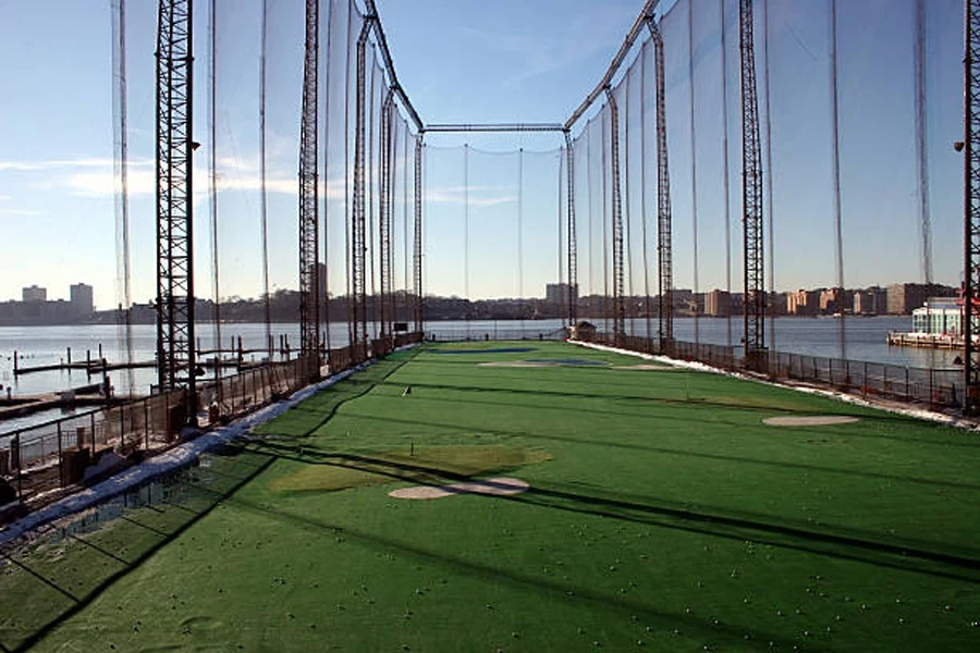 Alto campo de prácticas de golf junto al río en la ciudad