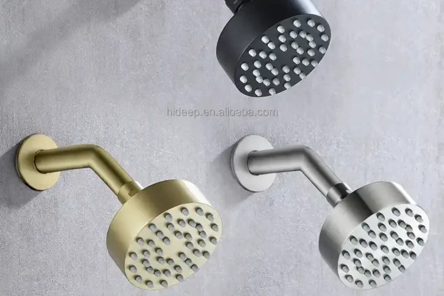 Three fixed shower heads on the wall in black, gold, and silver