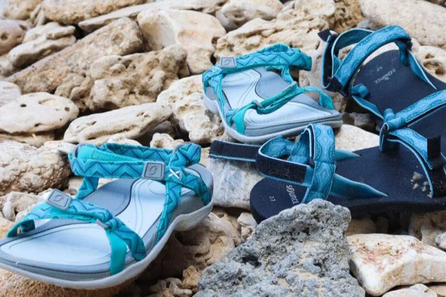 Две пары водных ботинок с открытым носком на камнях.