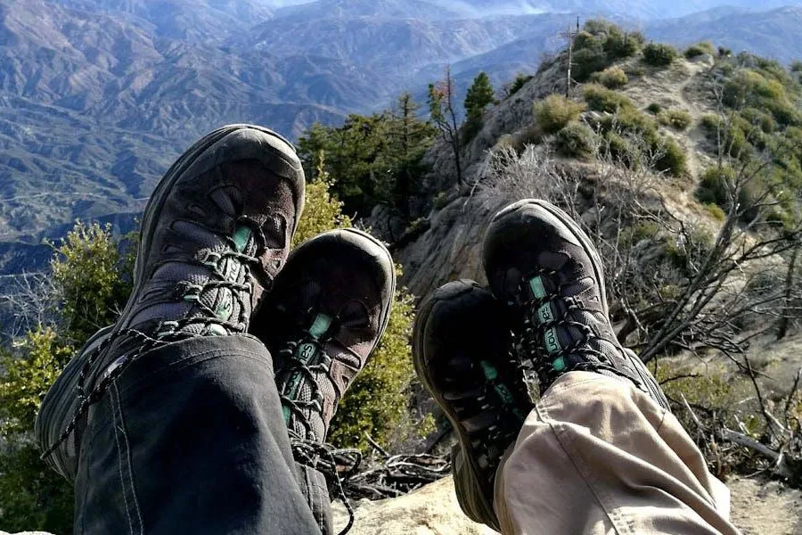 Two people showing off hiking boots