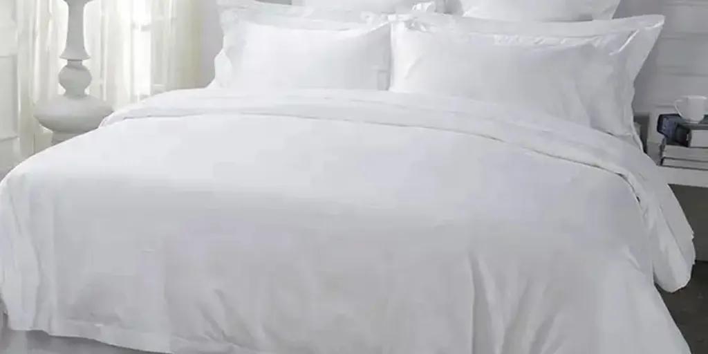 Tempat tidur mewah berbahan katun putih terletak di tempat tidur