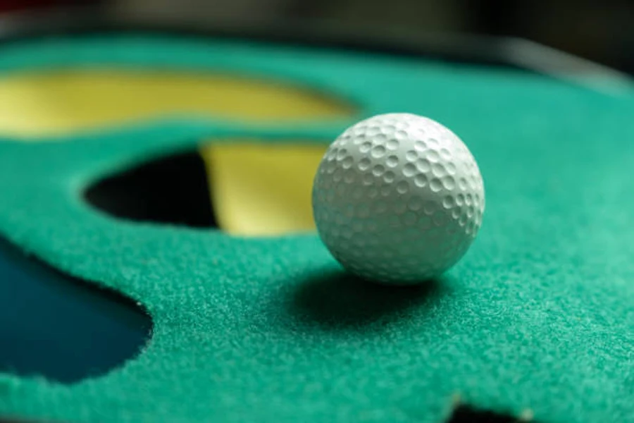 كرة جولف بيضاء بجوار الحفرة الموجودة على وضع اللون الأخضر