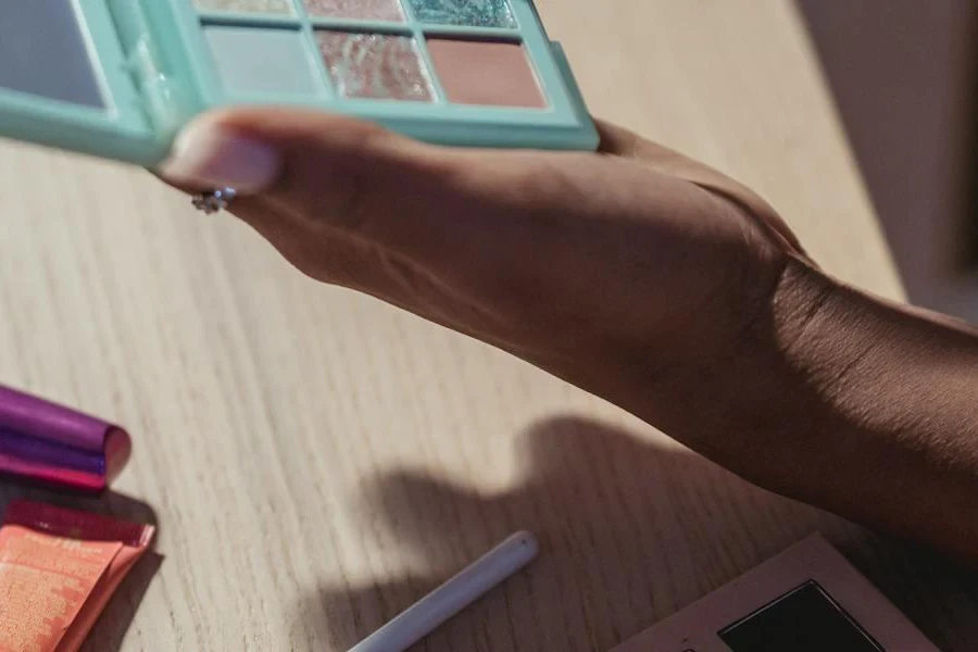 Frau hält eine blaue Make-up-Palette