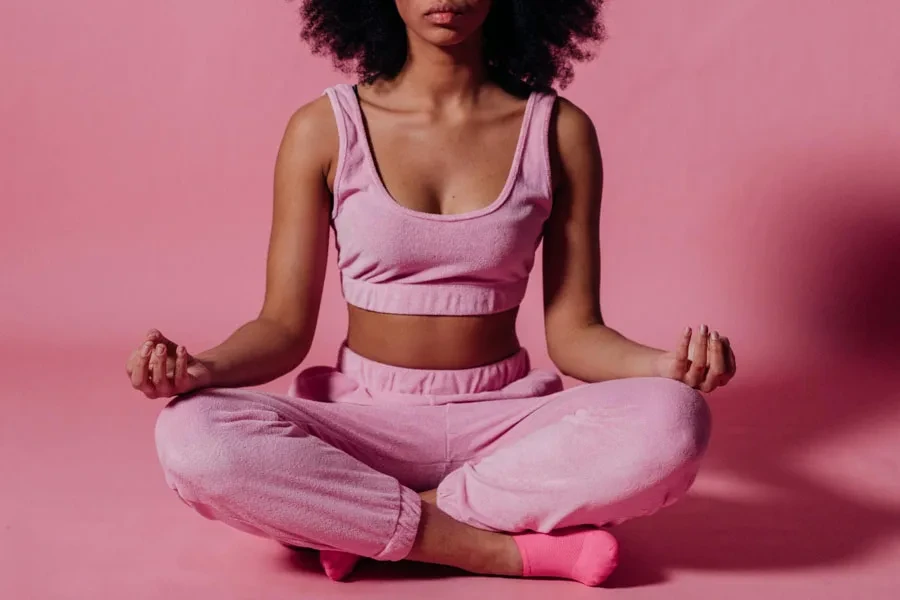 Mujer En Top Corto Rosa Y Pantalones De Chándal Practicando Yoga