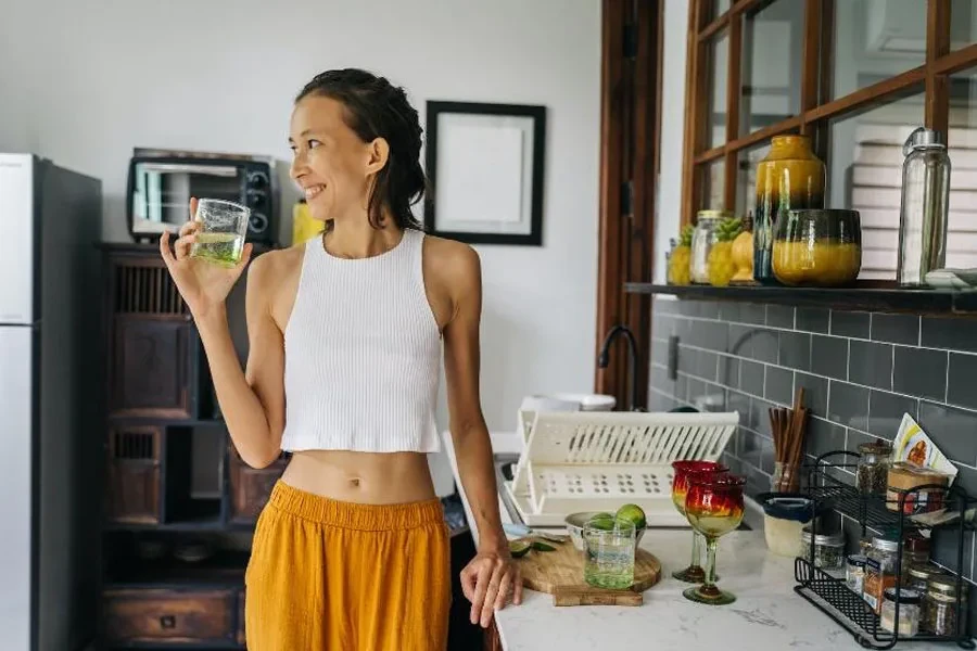 Woman in kitchen with white plastic foldaway dish rack