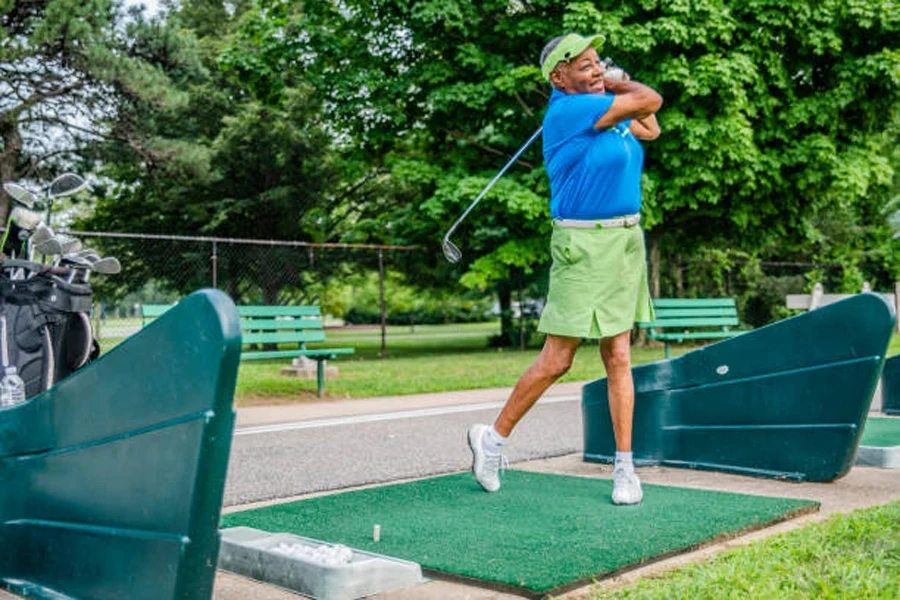 Mulher realizando tacadas de golfe em tapete de grama artificial