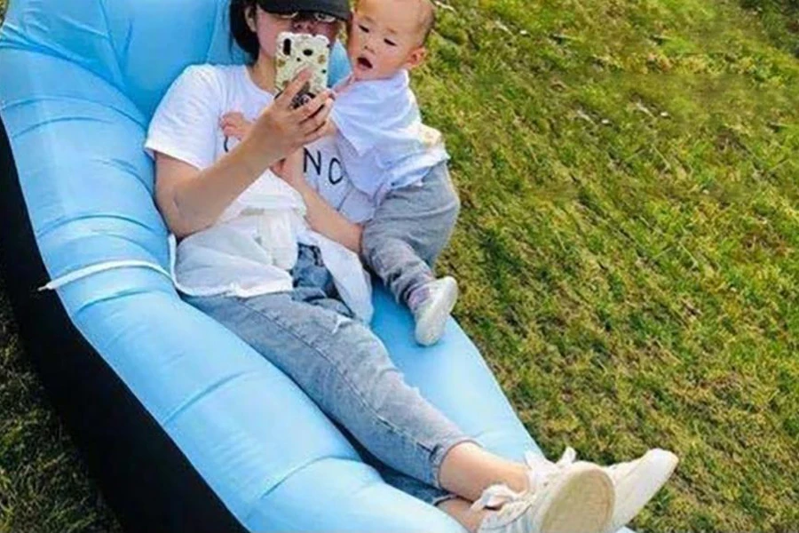 Mujer descansando con su bebé en un sofá inflable