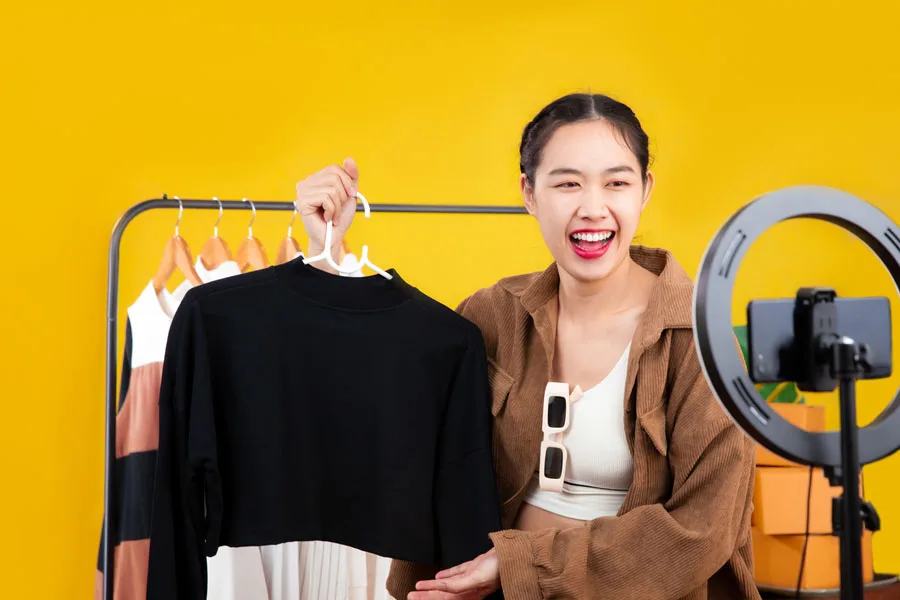 Young woman showing clothes in a live stream