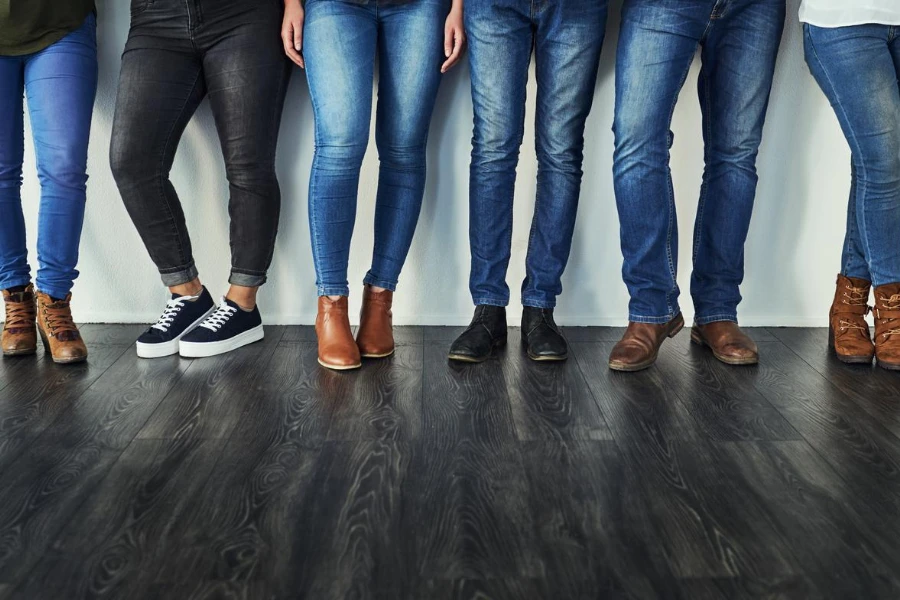 Обрезанный снимок группы неузнаваемых людей в джинсах, стоящих в ряд