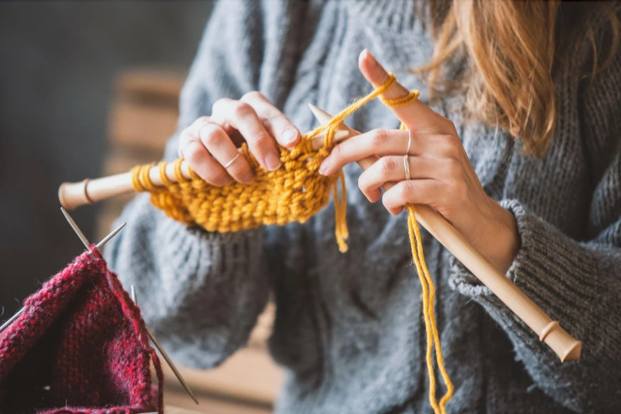 Primo piano sulle mani della donna che lavorano a maglia