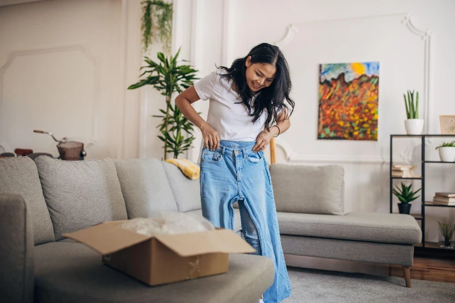 ela está experimentando os jeans que encomendou online