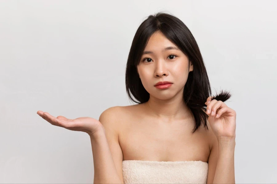 Una giovane donna coreana che si controlla i capelli