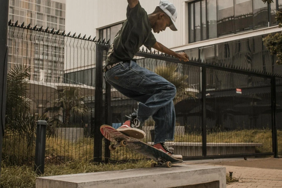 Seorang pria sedang melakukan trik skateboard di atas langkan beton (www.pexels.com)