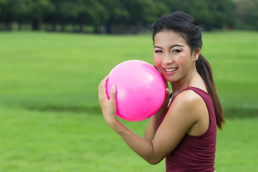 Chica asiática y bola rosa para juegos.
