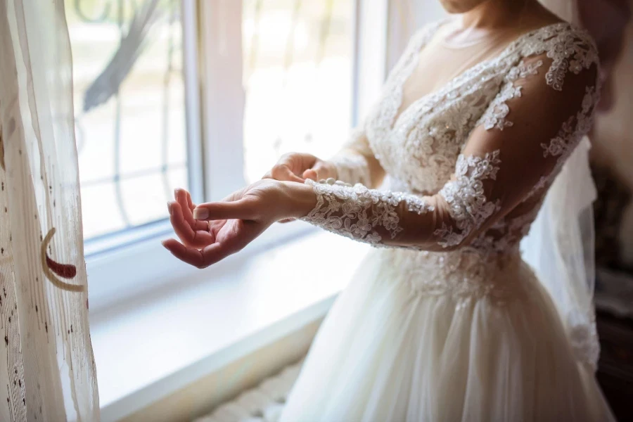 Chiudi le mani della sposa che sistema il suo vestito