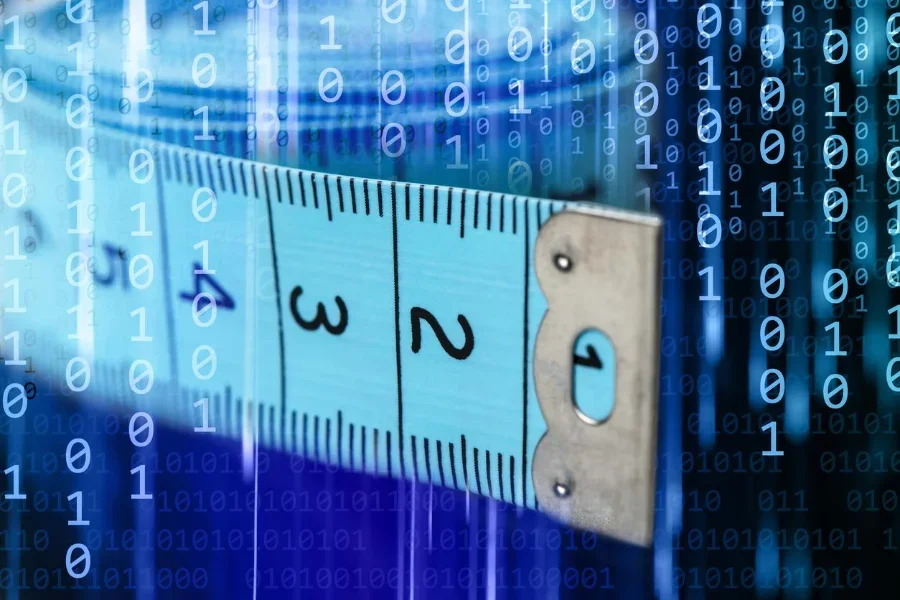 Primer plano de una cinta métrica sobre un fondo de código binario.