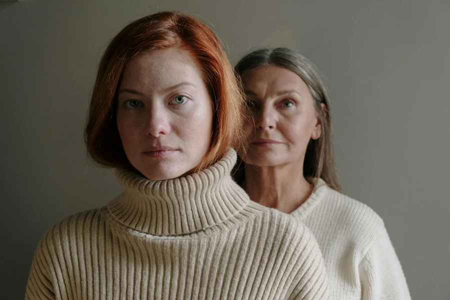 Foto na cabeça de mãe e filha em suéteres