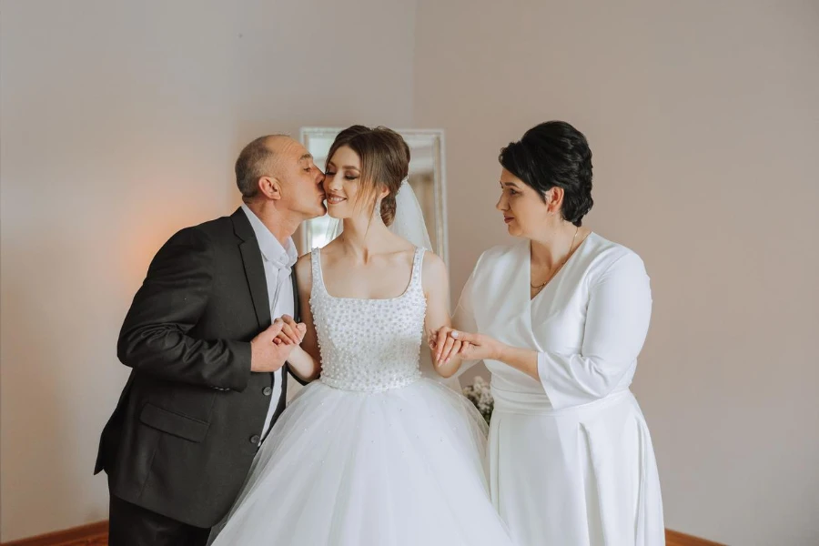 Padres felices toman las manos de la novia que se va a casar y la apoyan