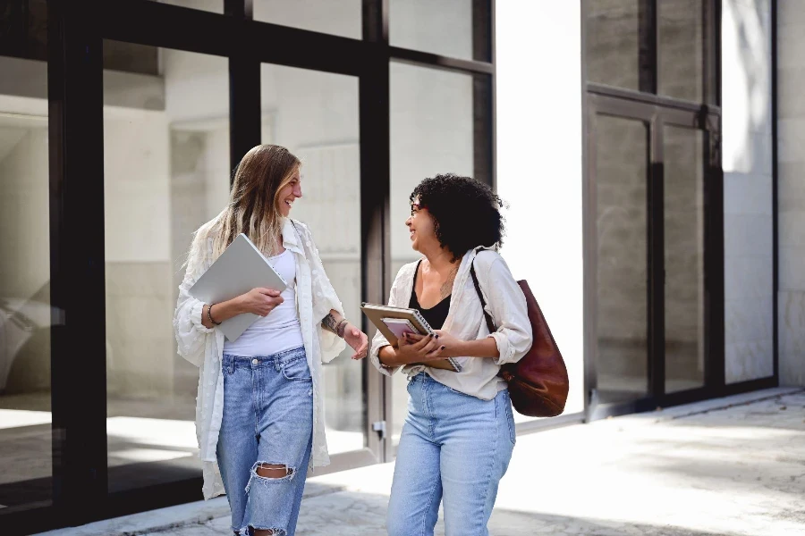 due donne che camminano per strada in jeans