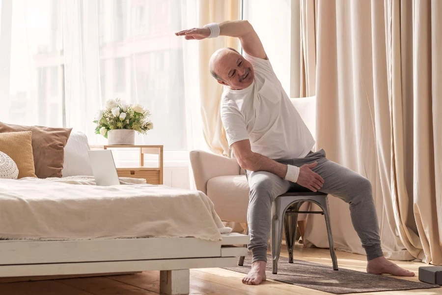 Senior man stretching side sitting on chair