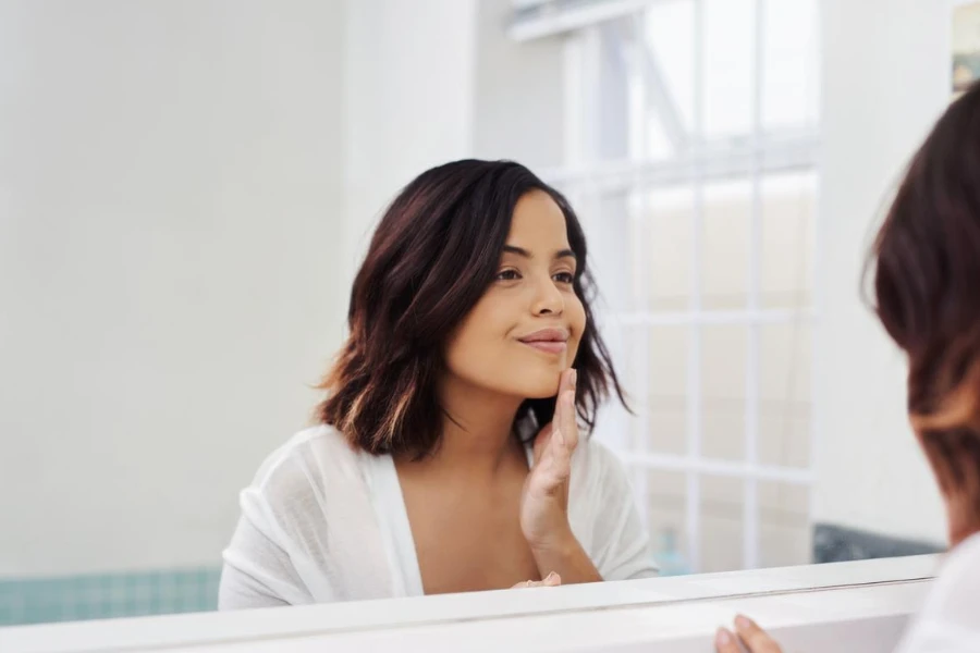 Çekici bir genç kadının banyoda sabah güzellik rutinini yaparken çekilmiş fotoğrafı