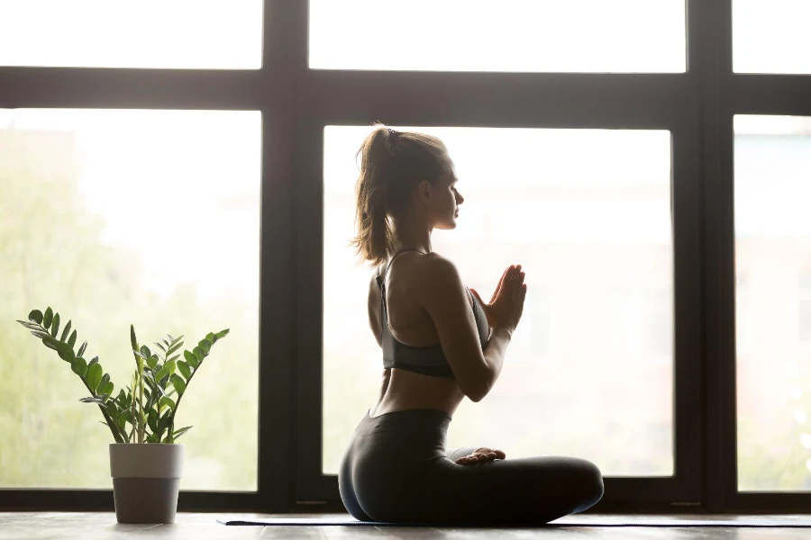 Junge sportlich attraktive Frau, die Yoga praktiziert
