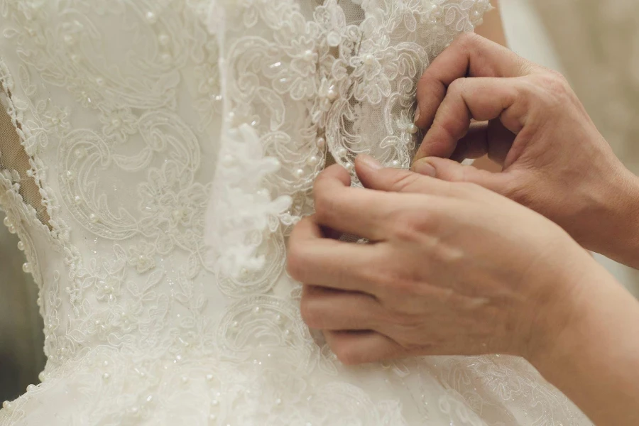 stilista che cucisce abiti da sposa foto d'archivio