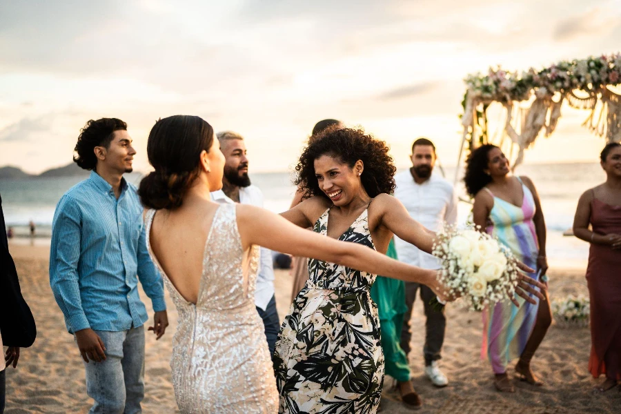 العروس تحتفل مع صديقتها في حفل زفاف على الشاطئ