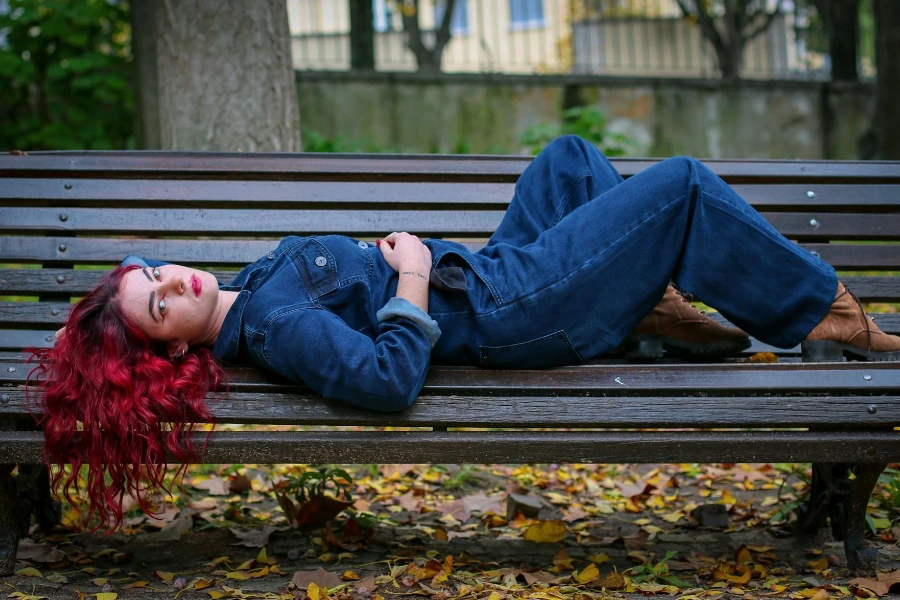 Eine Frau liegt mit offenem Haar auf einer Bank