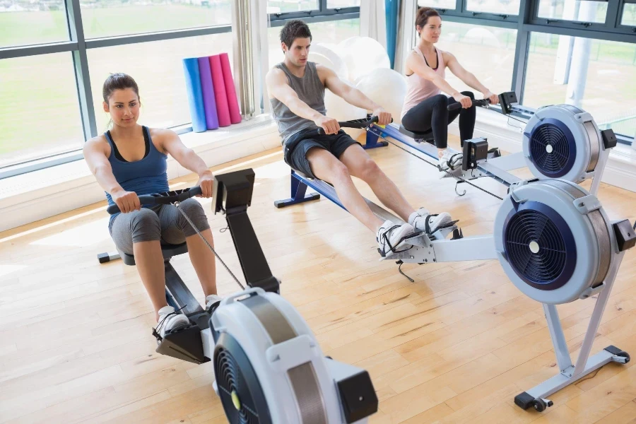 Pessoas usando máquinas de remo no estúdio de fitness