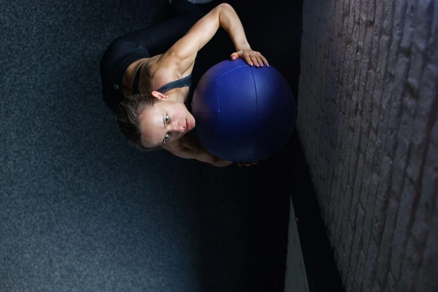 Wanita melakukan latihan bola di gym