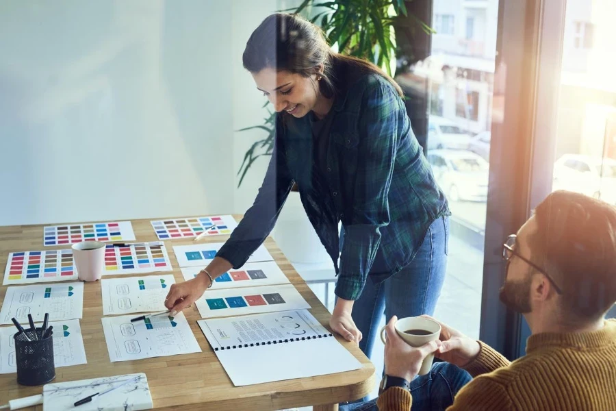 Gambar seorang pengusaha muda dan pengusaha wanita sedang mengerjakan dokumen bersama-sama di kantor modern