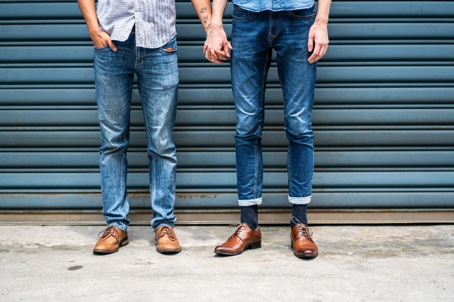 Unrecognizable male same-sex partners standing outside and holding hands on day