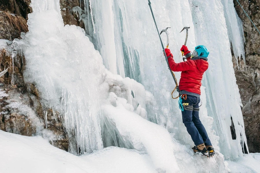 Alpinista de gelo vestido com grampos