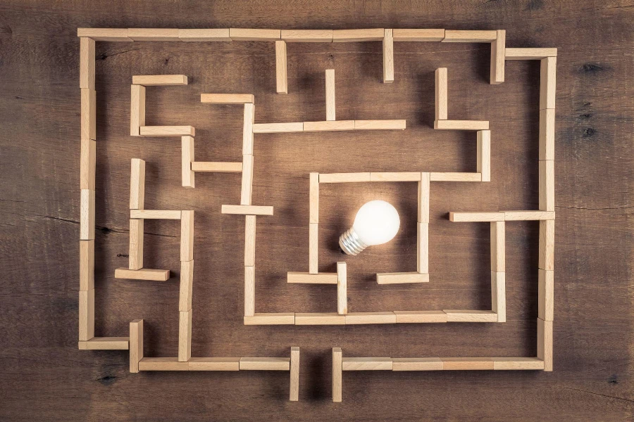 glowing small light bulb as the goal of the maze game built by wood blocks toy on the table