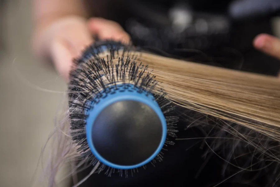 Mujer joven alisándose el cabello en una peluquería